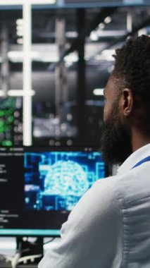 Verileri analiz etmek için derin öğrenme algoritmaları kullanan mühendis tarafından yapılan çalışmaları denetleyen dikey video veri merkezi denetleyicisi. Sunucu odası ekip lideri AI teknisyenini kullanarak verileri tanıyor.