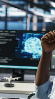 Dikey video sunucusu çiftlik denetçisi ve engelli adam sistem ayarlarını yapay zeka analizlerine göre ayarlar. Veri merkezi yöneticisi, tekerlekli sandalyedeki teknisyenle konuşuyor. Otomatik düğüm ağacını denetliyor.