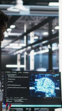 Dikey video sunucu merkezi yöneticisi yapay zeka veri analizi grafiklerini kontrol ediyor, çalışanı tebrik ediyor. Veri merkezi takım lideri, yapay zeka kullanarak yönetimle yumruk tokuşturuyor.