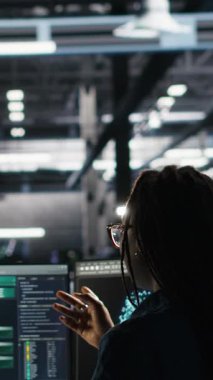 Sistem sağlığını optimize etmek için düğüm ağacı yazılımı kullanarak programcıyla konuşan dikey video sunucu merkezi yöneticisi. Veri Merkezi Yöneticisi AI kullanarak ekipman sorunlarını analiz eden bilişim uzmanını denetliyor