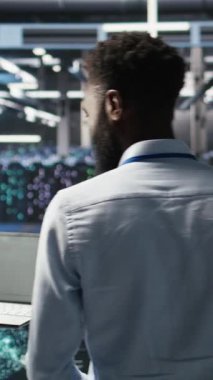 Dikey video sunucu merkez mühendislik ekibi yapay zeka veri analizi grafiklerini yorumluyor. Öngörü sistemi ölçümleri gösteren yapay zeka programı kullanan takım çalışması veri merkezi meslektaşları