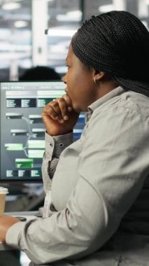 Donanım yapılandırmak için yapay zeka derin öğrenme modelleri kullanan dikey video veri merkezi teknisyeni. Afrikalı Amerikalı kadın sunucu odasında yapay zeka programlama dili üzerinde çalışıyor.