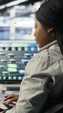 Dikey video sunucu odası bilişim uzmanı, sistem kapanma süresini en aza indirmek için yapay zeka teknolojisi uyguluyor. Yapay zeka çözümlerini optimize etmek ve uygulamak için dizüstü bilgisayar kullanan teknisyen