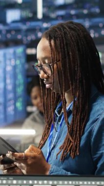 Sunucu merkezindeki dikey video kadın sistem sağlığını optimize etmek için tablet cihazındaki yapay zeka görselleştirme anlayışını kullanıyor. Veri Merkezi bilgisayar bilimcisi düğüm ağacı araçları kullanarak altyapı sorunlarını analiz ediyor