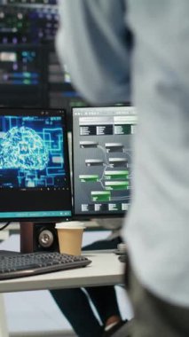 Dikey video sunucu merkez mühendislik ekibi yapay zeka veri analizi grafiklerini yorumluyor. Öngörü sistemi ölçümleri gösteren yapay zeka programı kullanan takım çalışması veri merkezi meslektaşları