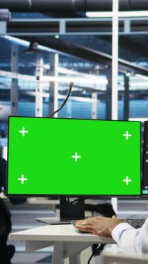 Yeşil ekran PC kullanarak dikey video veri merkezi yönetimi düğüm ağacı programlama ve kaynak tahsisini optimize ediyor. Sunucu odasındaki adam yapay zeka öngörü sistemleri ve kamera kullanıyor.