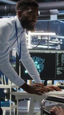 Dikey video sunucusu çiftlik denetçisi ve engelli adam sistem ayarlarını yapay zeka analizlerine göre ayarlar. Veri merkezi yöneticisi, tekerlekli sandalyedeki teknisyenle konuşuyor. Otomatik düğüm ağacını denetliyor.