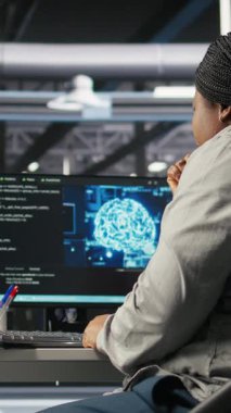 Donanım yapılandırmak için yapay zeka derin öğrenme modelleri kullanan dikey video veri merkezi teknisyeni. Afrikalı Amerikalı kadın sunucu odasında yapay zeka programlama dili üzerinde çalışıyor.