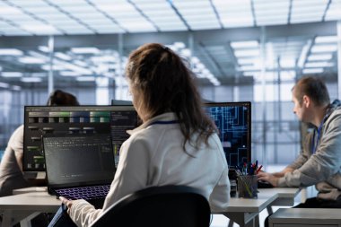 Yapay zeka sunuculuğunda IT personeli programlaması makine öğrenme eğitimi için kullanılan gelişmiş ekipmanları barındırıyor. Yapay zeka donanımlarını güncellemek için dizüstü bilgisayarda kod kullanan kadın.