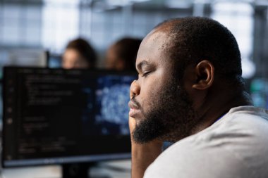 Yorgun adam veri merkezini optimize etmek için yapay zeka teknolojisi kullanırken uykuya dalıyor. Tükenmiş sunucu merkezi uzmanı yapay zeka teknolojisini kullanarak işlemleri düzene sokmaya ara veriyor.