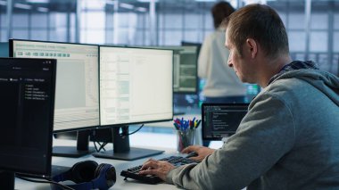 Mühendis, sunucu merkezinde büyük miktarda veri işlemek için kullanılan iş değişimine başlıyor. Bilgi İşlem Programcısı veri merkezine geliyor, bilgisayar masasında oturuyor, klavyeye, kamera A 'ya daktilo yazıyor.