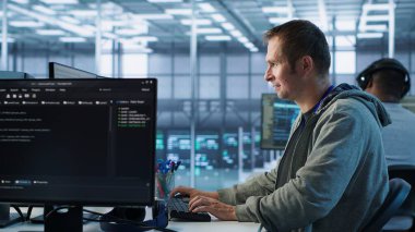 Sunucu merkezinde çalışan ve büyük miktarda veri işleyebilen bir adam. Klavyeye yazı yazan bilgisayar programcısı, ağ kaynaklarını kontrol eden sunucular güncelleniyor, kamera A