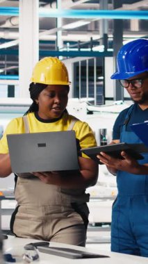 Dikey Video Güneş Panelleri Mühendisleri ekibi üretim tesisinde bulunan cihazları kullanarak yeni fotovoltaik materyaller geliştiriyor. Siyahi işçi grubu daha iyi üretim bandı için deneyler yapıyor. Kamera.