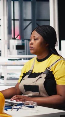 Vertical Video Black mühendisi yenilenebilir enerji tesisinde güneş enerjisini test ediyor, yazılım sorunları ve performans ölçümlerine odaklanıyor. Çevre dostu sanayi operasyonlarını destekliyor