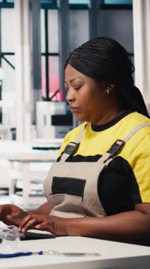 Verimli güneş enerjisi üretimini desteklemek için güneş paneli fabrikasında bilgisayar verileri üreten dikey video teknisyenleri, çalışanların ince ayar ayarları. Toplantının yanına oturan kadın