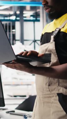 Fotovoltaik fabrikasındaki dikey video mühendisi arızalı sistemleri tespit etmek ve hata ayıklamak için dizüstü bilgisayar kullanıyor. Güneş panelleri üreten fabrika işçisi, çalışma süresini azaltıyor, sorun yaratıyor. Kamera B.