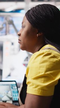 Dikey Video Afrikalı Amerikalı uzman güneş enerjisi santralindeki fotovoltaik sistemleri tasarım için bir PC yazılımı üzerinde çalışıyor. Mühendis yenilenebilir enerji işlemlerindeki yapılandırmaları inceliyor