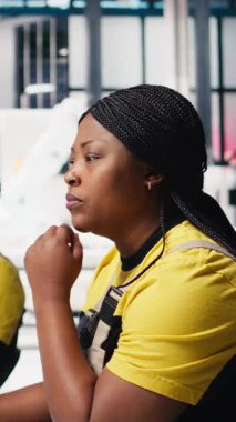 Dikey video Afrikalı Amerikalı işçi programları otomasyon ayarları güneş tesisinde, verimlilik ve sürdürülebilirlik üzerine odaklanmıştır. Kadın mühendis, gelişmiş güç çıkışı için yapılandırmaları yönetir