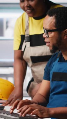 Fotovoltaik fabrikasındaki dikey video teknisyenleri güneş panelleri montaj hatlarını inceliyor, sanayi yönergelerini okuyor ve sorunsuz üretim sağlıyor. Siyah takım güneş pili etkinliğini optimize ediyor