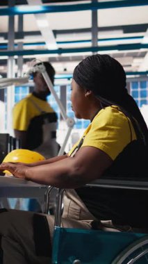 Dikey Video Photovoltaics fabrika mühendisi tekerlekli sandalye kullanıcısı endüstriyel yazılımda güneş panellerini geliştiriyor, imalat endüstrisinde bilgisayar üzerinde çalışıyor. Yenilenebilir enerji. Kamera B.