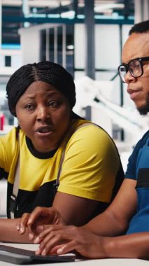 Dikey Video Çalışanları, temiz enerji santralindeki fotovoltaik tasarım güncellemeleri üzerinde çalışarak, bir güneş paneli fabrikasında operasyonel verimliliği azaltmaktadır. Mühendislerden oluşan siyah ekip teknik tamir yapıyor.