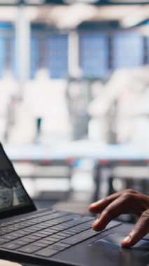 Dikey video güneş panelleri, erkek çalışanın dizüstü bilgisayardaki performans verilerini analiz etmesi ve verimliliği optimize etmesi. Fotovoltaik fabrikası mühendisi yenilikçi güneş pilleri dizaynı üzerinde çalışıyor, prototip, yüksek teknoloji.