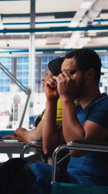 Dikey Afrikalı Amerikan tekerlekli sandalye kullanıcısı güneş paneli fabrikasında çalışarak yenilenebilir enerji sistemlerini optimize ediyor. Mühendis, engelli dostu bir enerji santralinde robot silah otomasyonunu inceliyor.