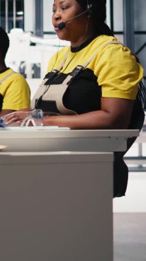 Dikey Video Afrikalı Amerikalı mühendis güneş paneli çağrı merkezinden destek ve bakım için yardım hattı taleplerini yönetme hizmeti sunuyor. Müşteri destek operatörü fabrika işlemlerini geliştiriyor