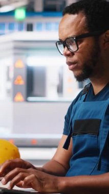 Dikey Video Güneş enerjisi uzmanı, araştırma ve yenilik odaklı çevre dostu fabrikada tasarım modellerini güncellemektedir. Erkek işçi dijital sistemler kullanarak sürdürülebilir endüstriyel büyümeyi destekliyor