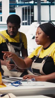 Fotovoltaik fabrikasındaki Dikey Video Mühendisleri ekibi arızalı sistemleri tespit etme yönergelerini inceliyor. Güneş panelleri fabrika personeli işletim için denetim veri dosyalarını okuyor