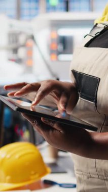 Dikey Video Black fotovoltaik fabrikası teknisyen izleme sistemi performansı tablet üzerinde. Güneş panelleri üretim tesisi yöneticisi yüksek üretimden memnun, verimliliği denetliyor. Kamera B.