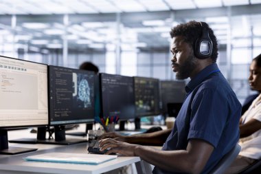 Sunucu odası çalışanı müzik dinliyor, PC 'de yüksek performanslı yapay zeka sistemleri yaratıyor. Veri merkezinde şarkı dinlemek için kulaklık takan, yapay zeka geliştiren bir yönetici.