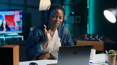 Video konferansındaki kadın kulaklıkla internetten yakın arkadaşını kontrol ediyor. Ses kulaklığı takan mutlu insan arkadaşlarıyla online video görüşmesinde eğleniyor. Kamera A.