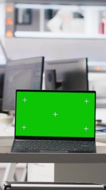 Güneş panelleri üretiminin performansını denetlemek için kullanılan fotovoltaik fabrikasındaki dikey video izole ekran monitörü. Güneş santralini incelemek için kullanılan boş endüstriyel tesisteki krom anahtar bilgisayar.