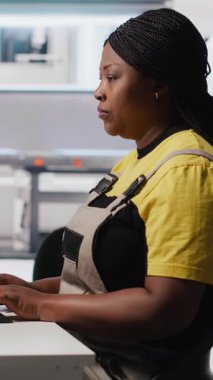 Verimli güneş enerjisi üretimini desteklemek için güneş paneli fabrikasında bilgisayar verileri üreten dikey video teknisyenleri, çalışanların ince ayar ayarları. Toplantının yanına oturan kadın