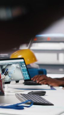 Dikey Afrikalı Amerikalı kadın çalışan, yenilenebilir enerji üretim endüstrisinde çalışarak çoklu güneş paneli tasarımlarını CAD yazılımı üzerinde test ediyor. Üretimi optimize eden kadın mühendis. Kamera A