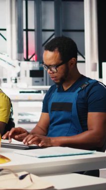 Dikey Video Çalışanı, yüksek teknolojili sürdürülebilir bir tesiste güneş enerjisi fabrikasında robotik silahları kontrol etmek için bilgisayar kullanır. Teknisyen otomasyon ayarlarını tutarlı üretimi destekleyecek şekilde ayarlar. Kamera B