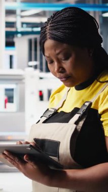 Dikey video güneş paneli üreten fabrika araştırmacısı tablet üzerine notlar alıyor, yeni güneş enerjisi sistemleri prototipleri geliştiriyor. Yeni fotovoltaik materyalleri inceleyen mühendis, bilgi yazıyor