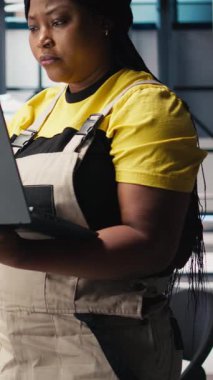 Dikey Video Photovoltaics fabrikası yöneticisi test denetimi için dizüstü bilgisayar kullanarak üretim sürecini inceliyor. Çevre dostu yenilenebilir enerji için güneş paneli yapılandırmalarını geliştiren kadın