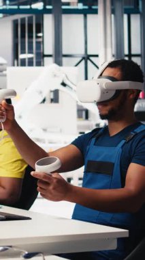 Güneş panellerindeki dikey video Afrikalı Amerikalı teknisyen VR gözlük kullanarak tesis kuruyor CAD yazılımı kullanarak yerleşimleri optimize ediyor. Fotovoltaik fabrika işçisi sanal gerçeklik teknolojisini kullanarak düzenlemeler yapıyor.