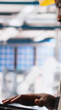 Fotovoltaik fabrikasındaki dikey video mühendisi arızalı sistemleri tespit etmek ve hata ayıklamak için dizüstü bilgisayar kullanıyor. Güneş panelleri üreten fabrika işçisi, çalışma süresini azaltıyor, sorun yaratıyor. Kamera A.