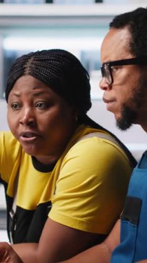 Dikey Video Çalışanları, temiz enerji santralindeki fotovoltaik tasarım güncellemeleri üzerinde çalışarak, bir güneş paneli fabrikasında operasyonel verimliliği azaltmaktadır. Mühendislerden oluşan siyah ekip teknik tamir yapıyor.