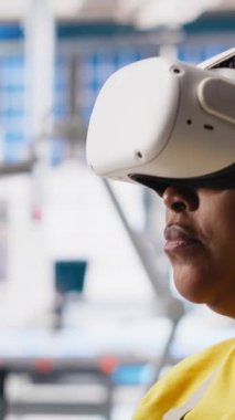 Fotovoltaik fabrikasındaki dikey video mühendisi arızalı sistemleri teşhis etmek için sanal gerçeklik ekipmanı kullanıyor. Kadın güneş panelleri denetleme için VR kulaklık kullanan fabrika işçisi, yüksek teknoloji