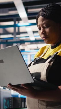 Dikey Video Güneş panelleri üretim tesisi denetleyicisi dizüstü bilgisayar kullanarak yeni fotovoltaik materyaller ve teknolojiler geliştirir. İnce işçilik üretimi için fabrika uzmanı teftişi yapıyor. Kamera.