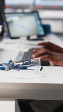 Dikey Video Black mühendisi otomatikleştirilmiş fabrikada güneş yazılımı ayarları üzerinde çalışarak üretim sürecini optimize ediyor. Dijital araçlar ve endüstriyel robotik kullanarak optimal sistem yapılandırmasını sağlarName