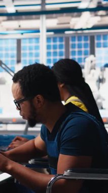 Dikey Video Afro-Amerikan tekerlekli sandalye kullanıcısı güneş enerjisi endüstrisinde çalışan fabrika mühendisi CAD yazılımını test ediyor. İşinde engelli bir uzman. Kamera B.