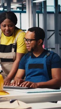 Fotovoltaik fabrikasındaki dikey video teknisyenleri güneş panelleri montaj hatlarını inceliyor, sanayi yönergelerini okuyor ve sorunsuz üretim sağlıyor. Siyah takım güneş pili etkinliğini optimize ediyor