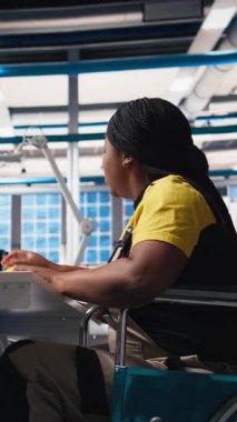 Dikey Görüntü Photovoltaics fabrikası çalışanı güneş paneli üretiminin performansını izlemek için PC kullanıyor. Mühendis maluliyet dostu endüstriyel tesiste çalışıyor. Kamera B.