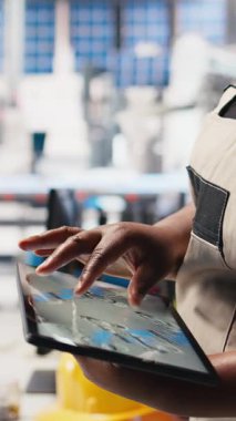 Dikey Video Photovoltaics fabrikası çalışanı tablet üzerindeki güneş modülleri için CAD teknik çizimleri inceleyerek montaj sürecini inceliyor. Aygıt üzerinde güneş paneli tasarımları geliştiren teknisyen