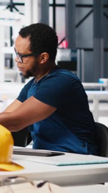 Dikey Video Afrikalı Amerikalı teknisyen güneş pillerinin performans raporlarını PC 'de analiz ediyor, çevre dostu yenilenebilir enerji üzerine odaklanıyor. Çalışan sürdürülebilirliği desteklemek için fotovoltaik çıktıyı izler